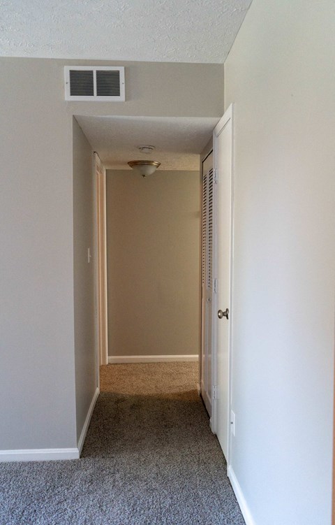 a room with a hallway and a door to a closet