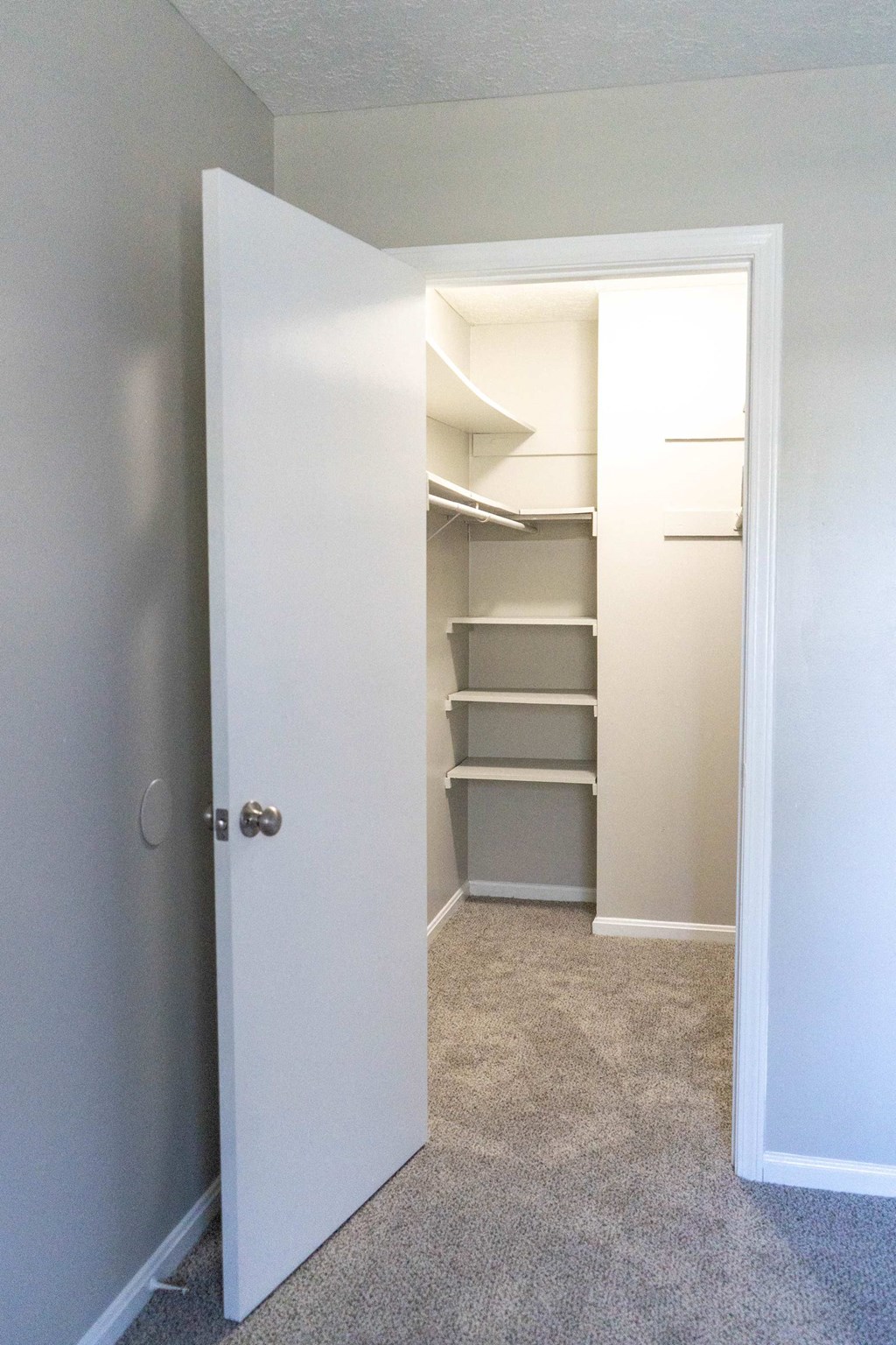 a walk in closet with shelves and a white door