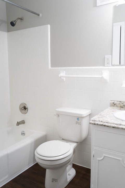 a white bathroom with a toilet and a tub