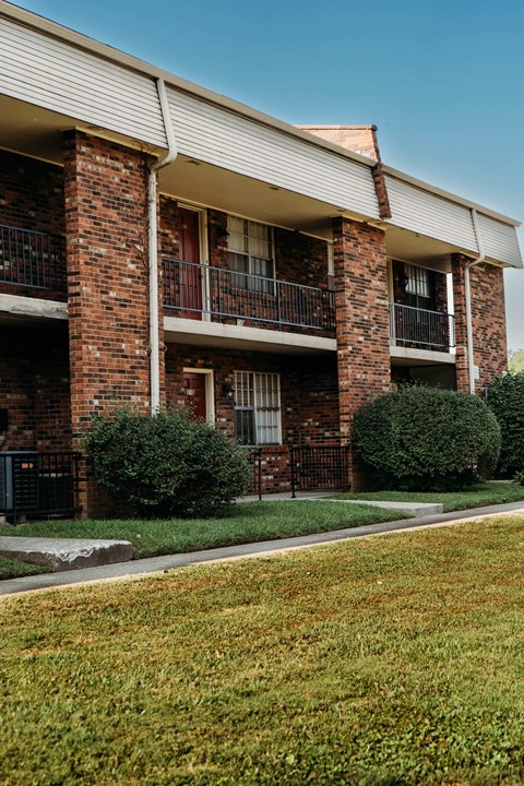 an apartment building with red brick and green grass