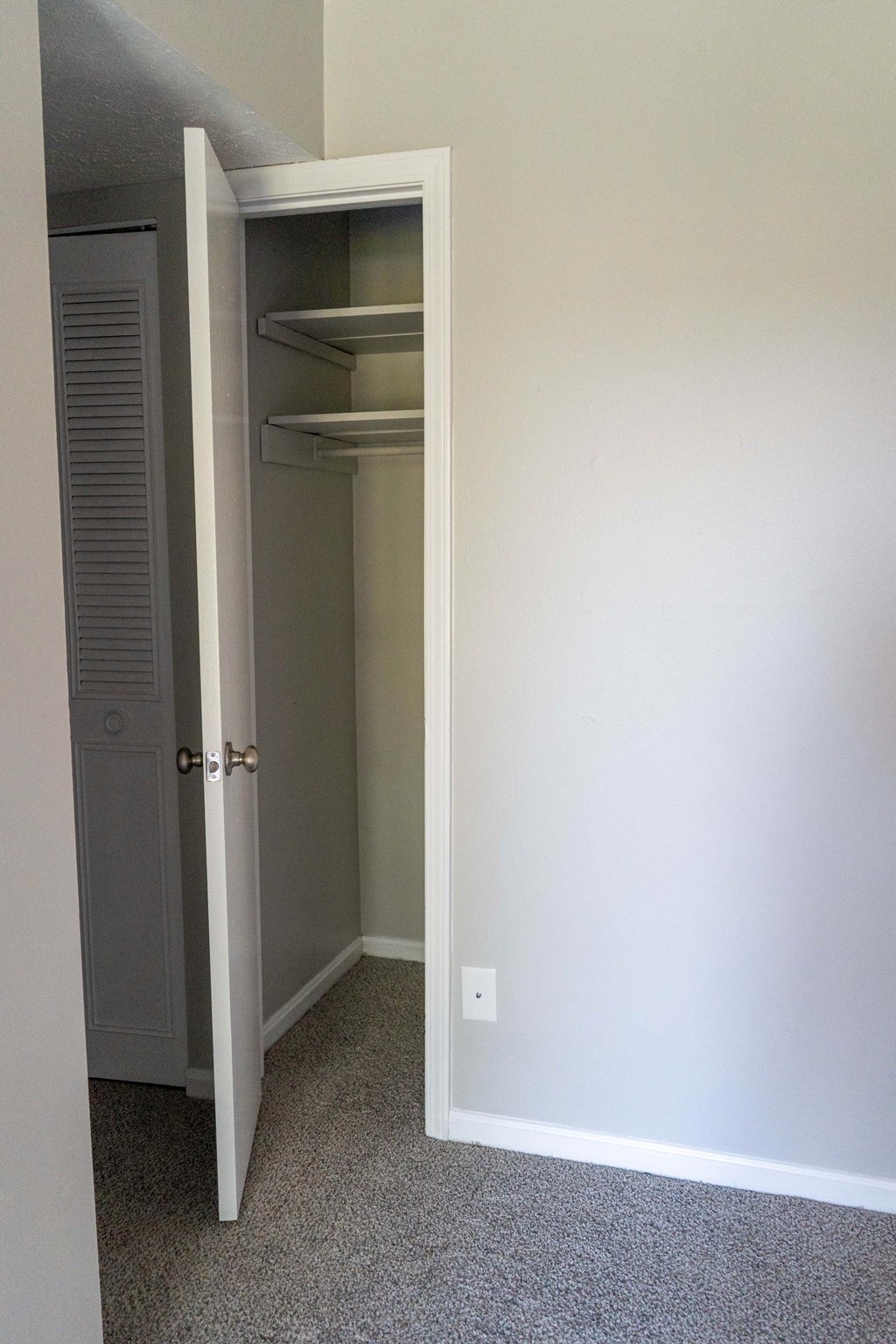 a closet with an open door and a door to a closet