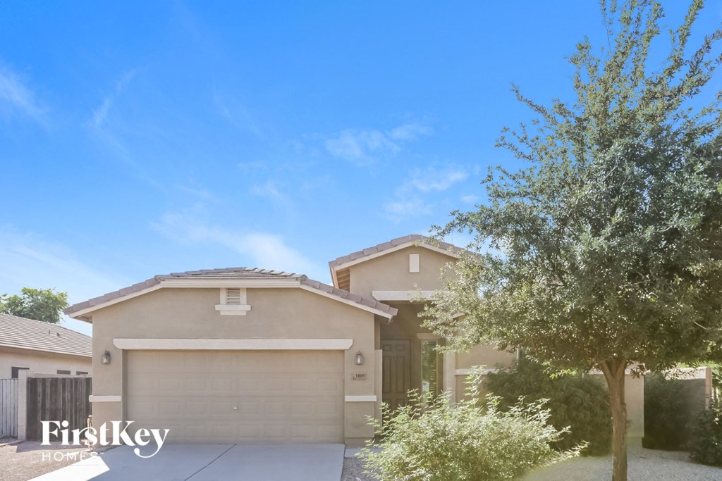 a house with a garage door and a tree