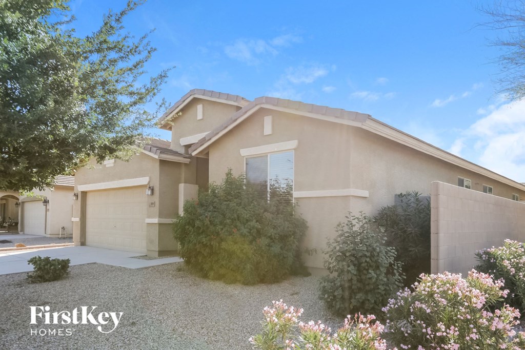 a beige house with a driveway and a garage door