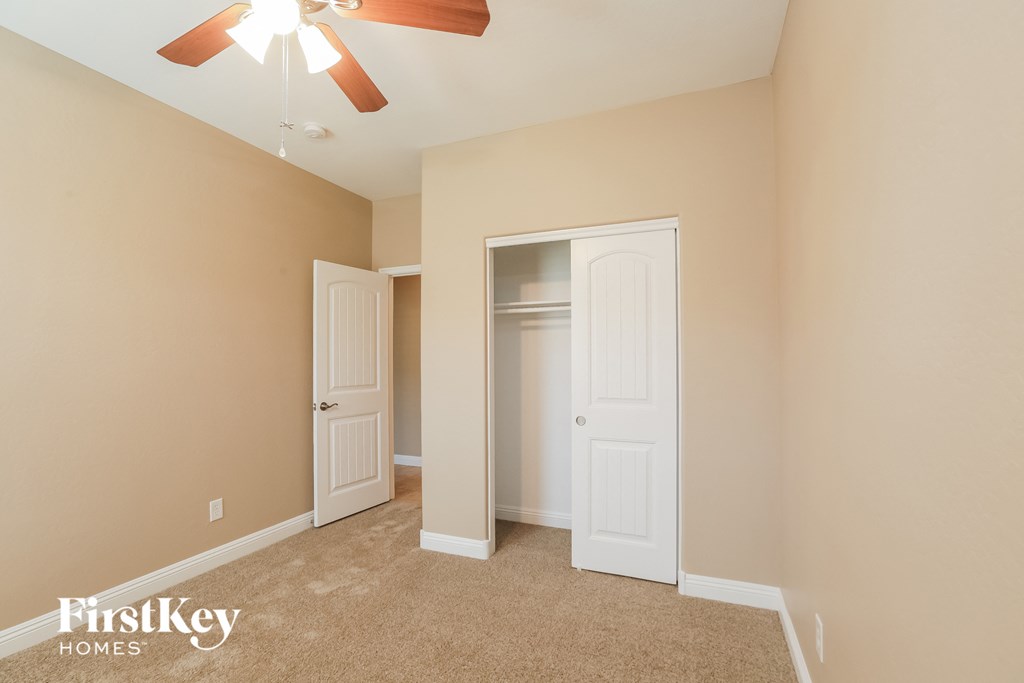 a bedroom with a closet and a ceiling fan