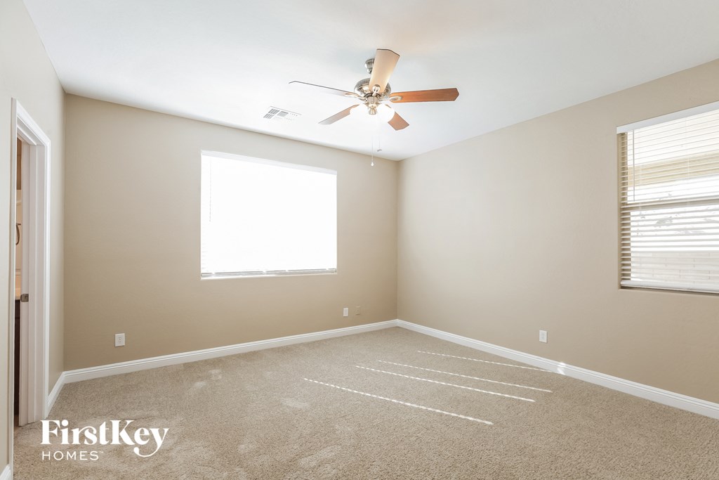 a bedroom with a ceiling fan and a window