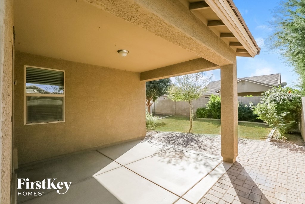 a view of the patio of a house with a driveway and a garden