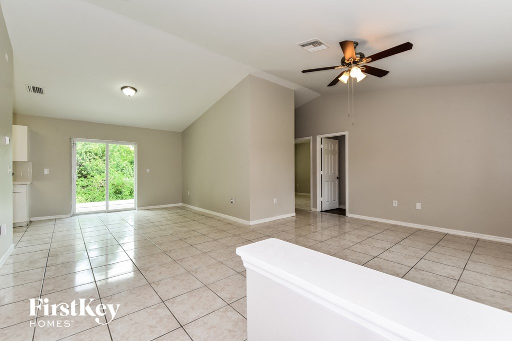 A spacious room with a ceiling fan and a bathtub in the foreground.