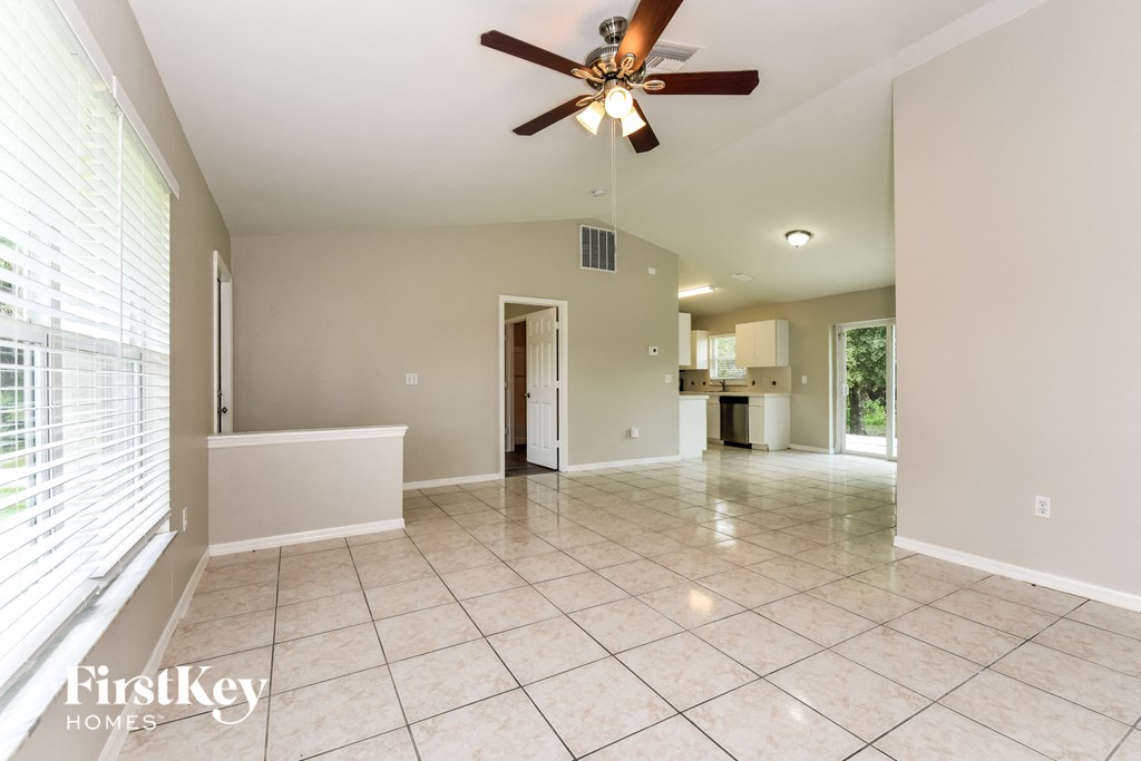 A spacious room with a ceiling fan and tiled flooring.