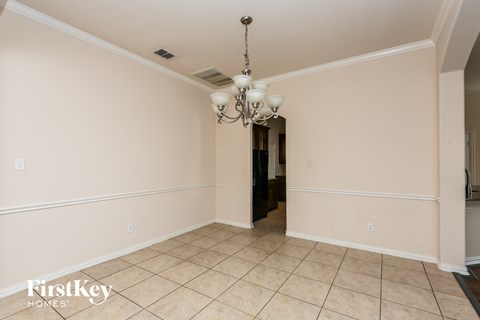 A spacious room with a chandelier and tiled flooring.