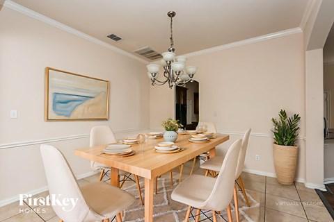 A dining room with a wooden table and chairs.