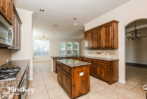 A kitchen with wooden cabinets and a granite countertop.