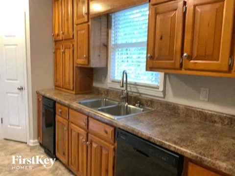 A kitchen with wooden cabinets and a granite countertop.