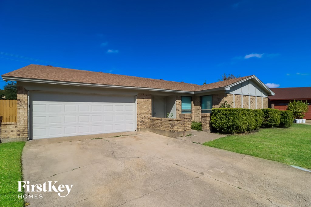 A house with a garage and a driveway is for sale.