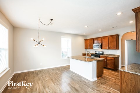 A kitchen with wooden cabinets and a white island.