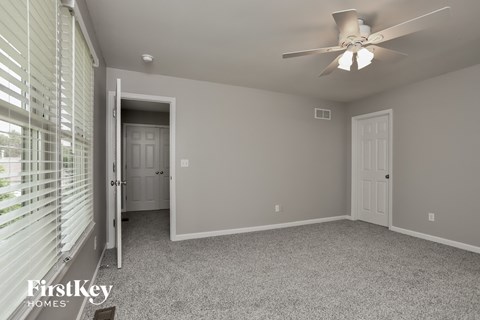 a bedroom with a ceiling fan and a window