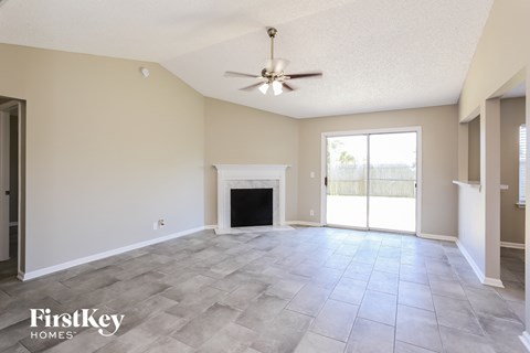 A spacious living room with a fireplace and sliding glass doors.