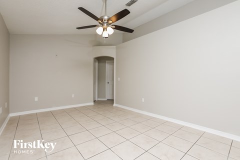 A spacious room with a ceiling fan and tiled floor.