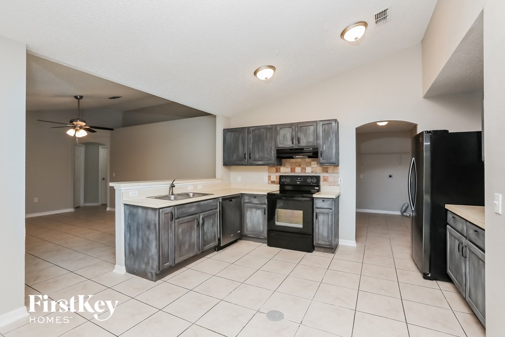 A kitchen with a black oven and a black fridge.
