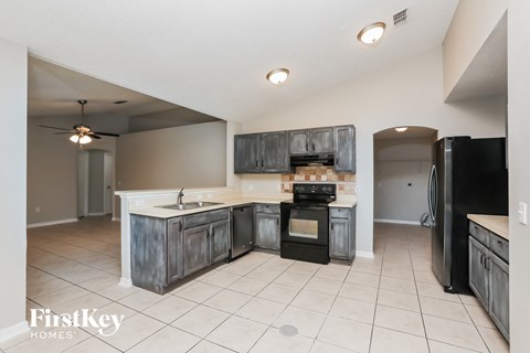 A kitchen with a black oven and a black fridge.