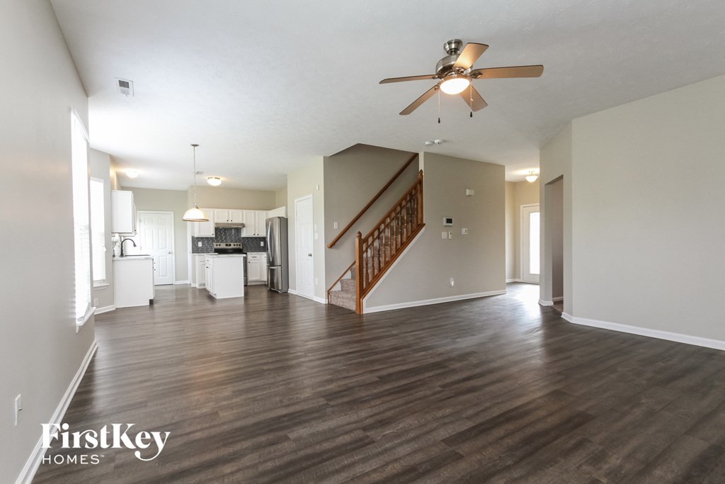 an open living room and kitchen with a ceiling fan