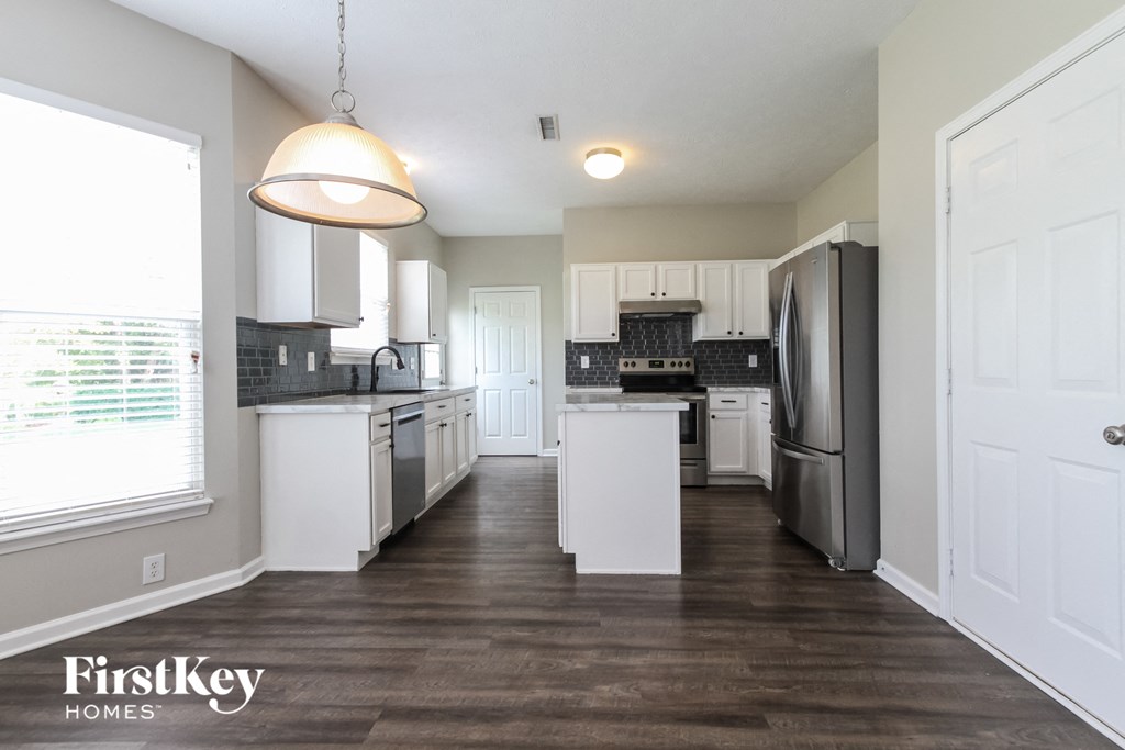 a renovated kitchen with white cabinets and stainless steel appliances