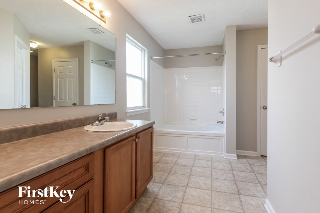 a bathroom with a large mirror and a sink and a tub