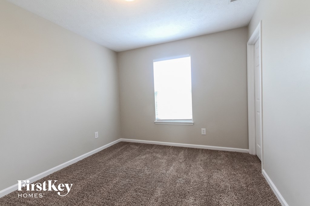 an empty room with carpet and a window