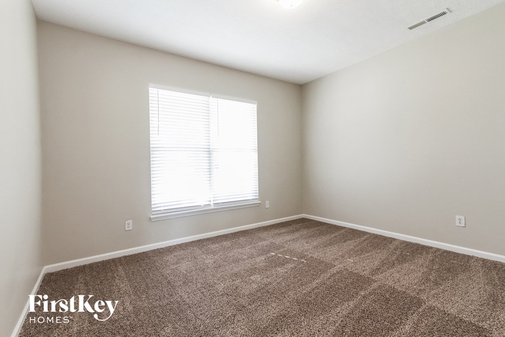 an empty room with carpet and a window