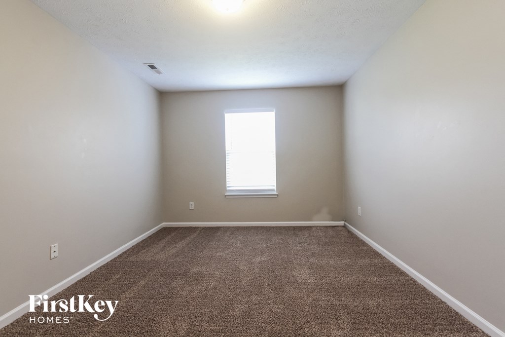 an empty room with carpet and a window