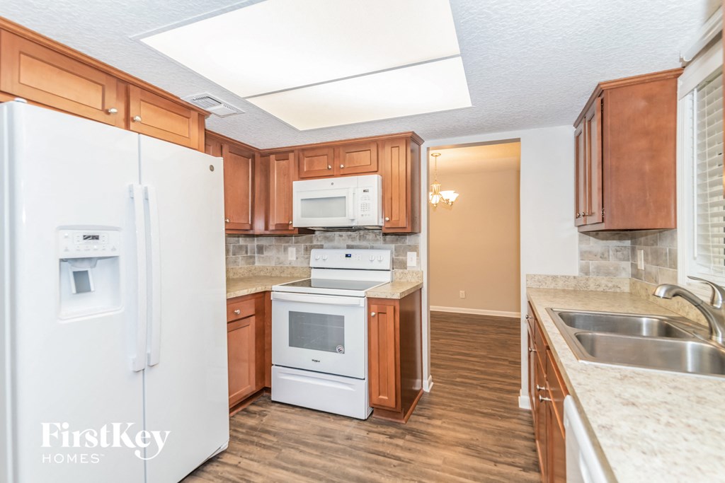 a kitchen with white appliances and wooden cabinets