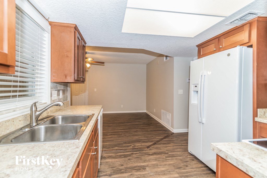 a kitchen with wooden cabinets and a sink and a refrigerator
