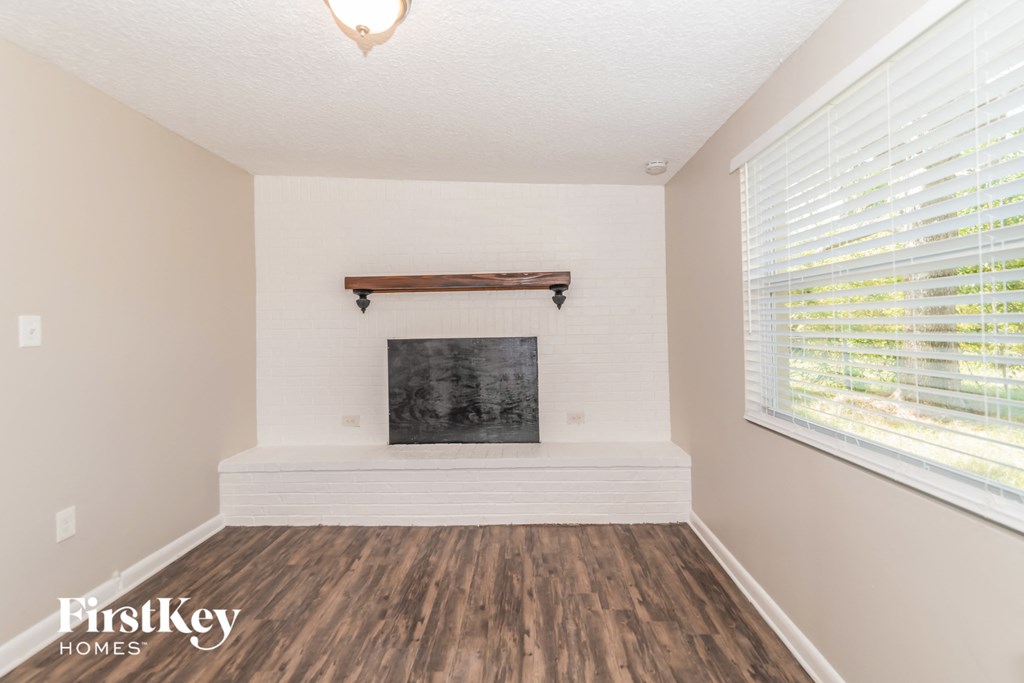 a living room with a fireplace and a large window