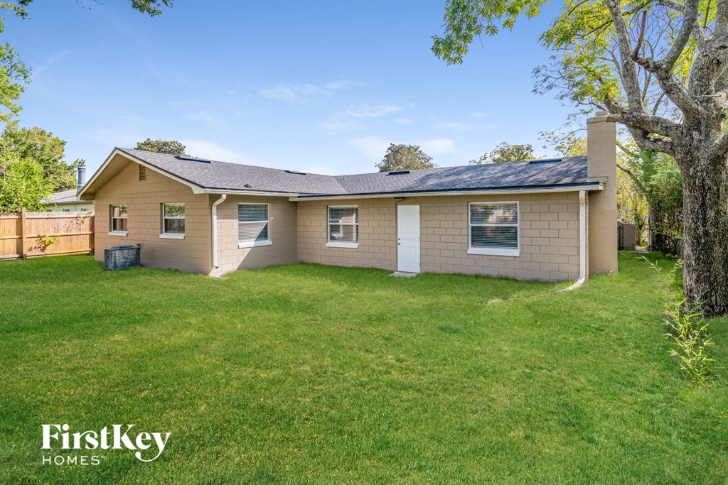 a small brown house with a yard and a tree