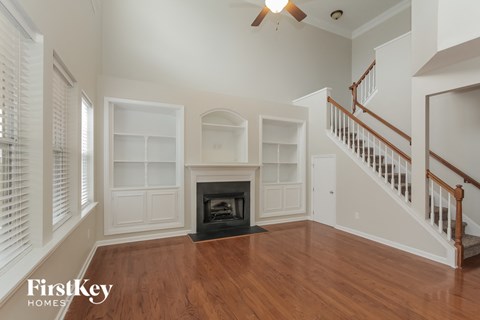 A living room with a fireplace and a staircase.