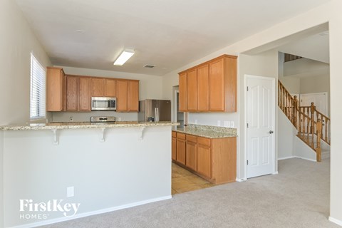 a kitchen with an island and wooden cabinets and a stairway