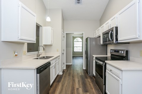 a kitchen with white cabinets and stainless steel appliances