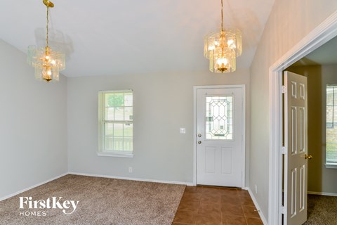 A room with a carpeted floor and two hanging lights.