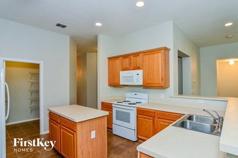 A kitchen with wooden cabinets and a white fridge.