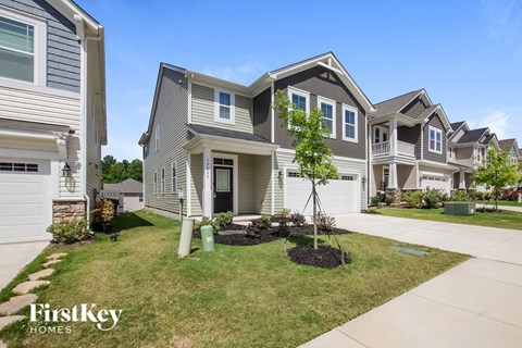 a group of houses in a neighborhood with grass and a sidewalk