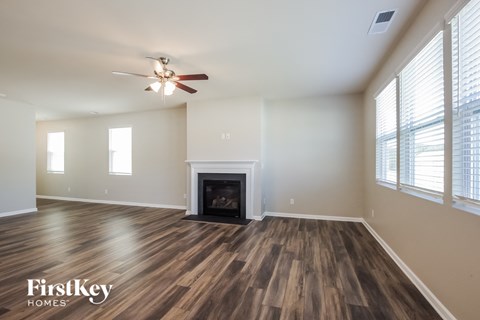 the living room with wood flooring and a fireplace