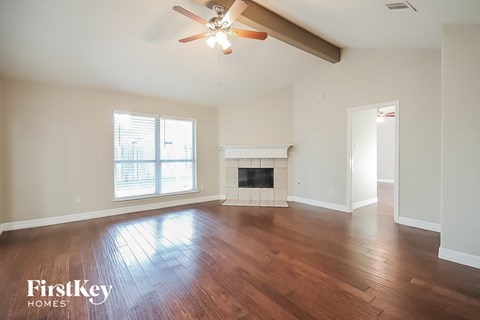 a living room with a fireplace and a ceiling fan