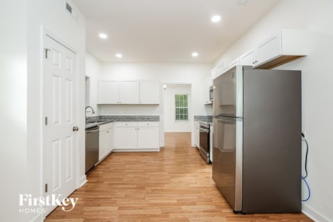 a kitchen with white cabinets and stainless steel appliances