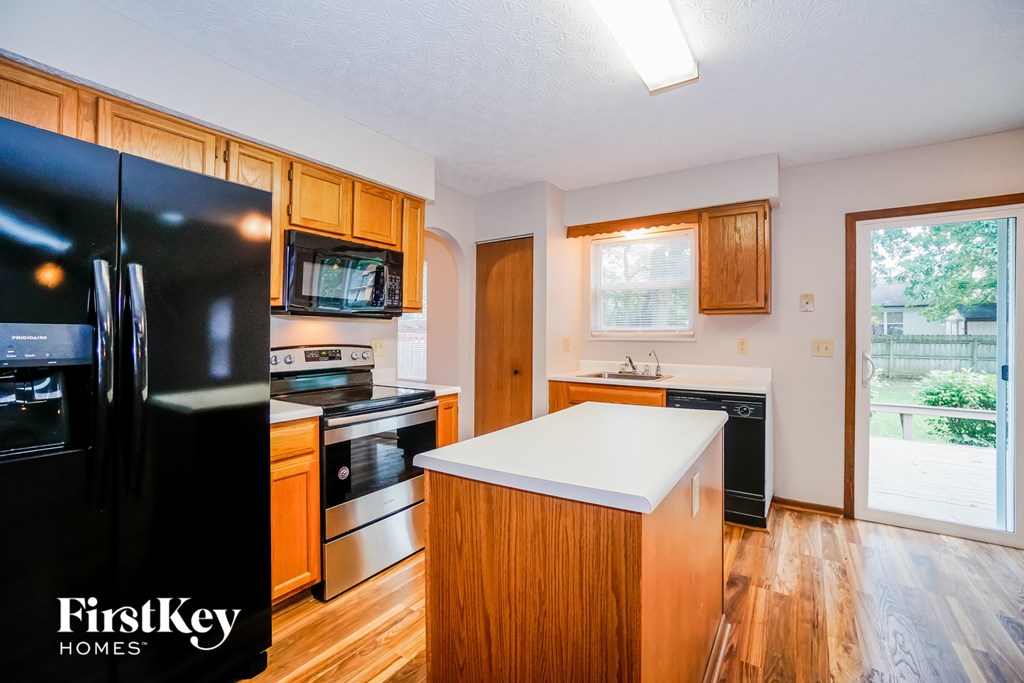 photo of a kitchen with black appliances and wooden cabinets