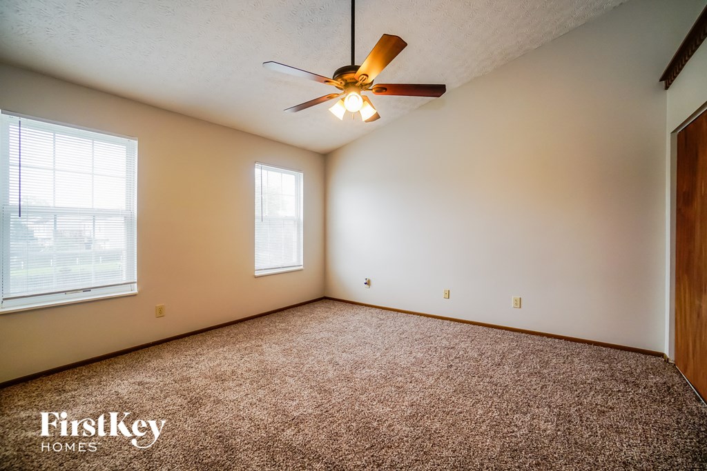 the master bedroom has a carpeted floor and a ceiling fan