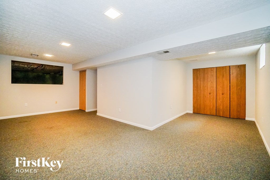 a room with white walls and carpet and a door to a closet