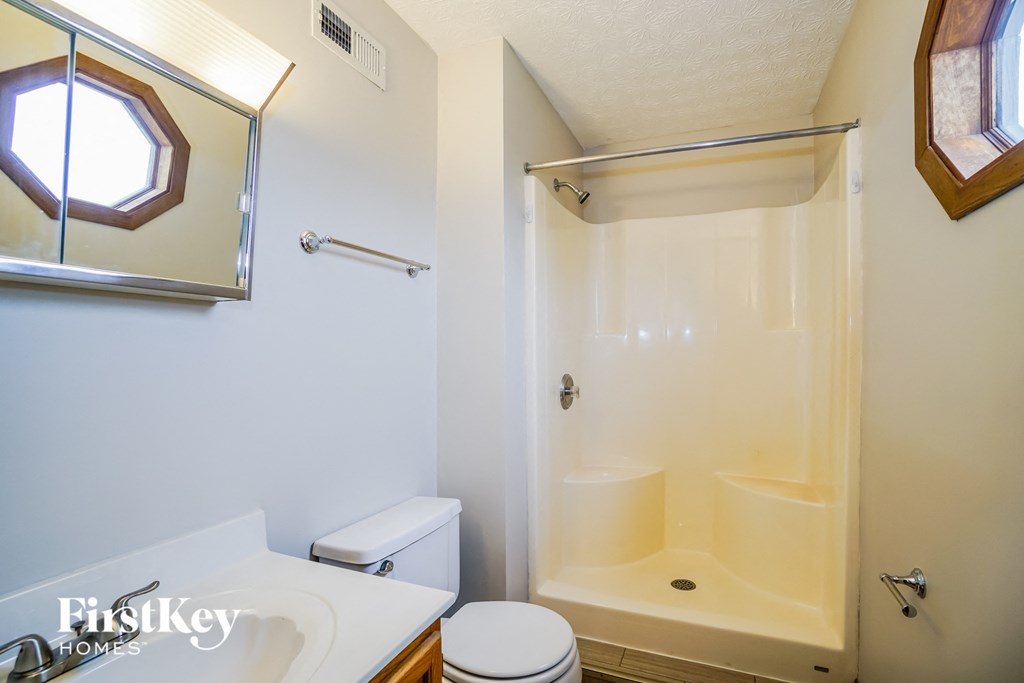 a bathroom with a shower and a toilet and a sink