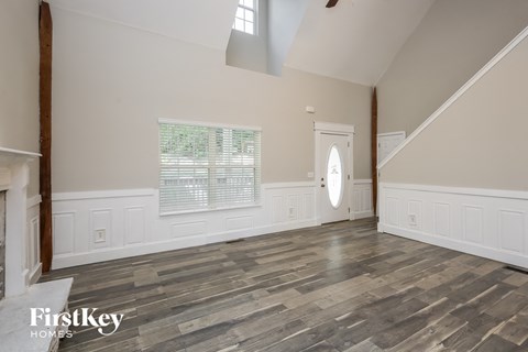 the living room with wood floors and white walls and a white door
