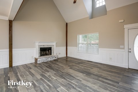 the living room of a home with a fireplace and wooden floors