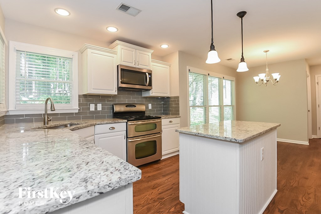 A kitchen with a granite countertop and white appliances.