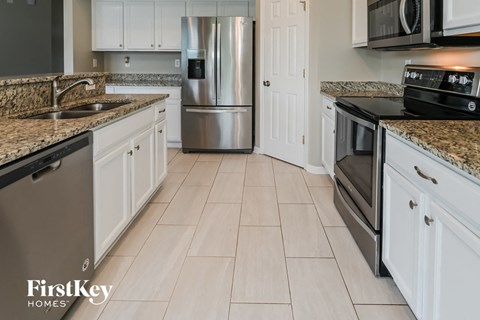 A kitchen with a granite countertop and stainless steel appliances.
